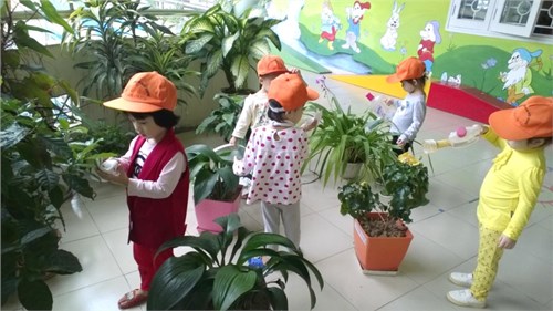 Các bé học sinh chăm sóc cây xanh và bảo vệ môi trường